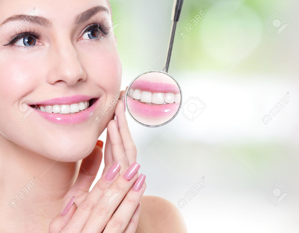 25112546-attractive-smiling-woman-face-with-health-teeth-close-up-and-a-dentist-mouth-mirror-dental-care-conc-Stock-Photo
