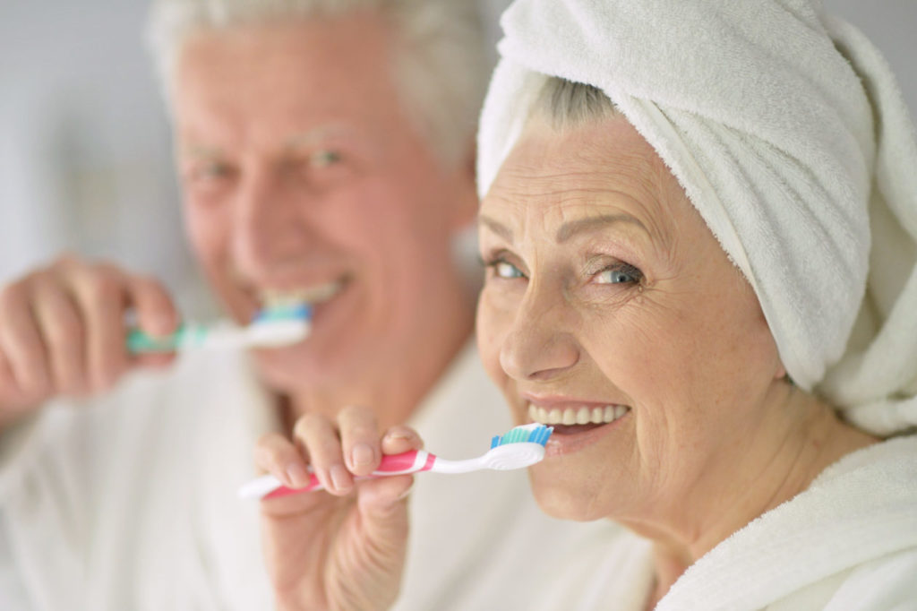 Senior couple with toobrushes in a bath
